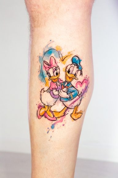 Donald und Daisy Duck umarmen sich, farbenfrohes Aquarelle-Tattoo auf einem Bein.