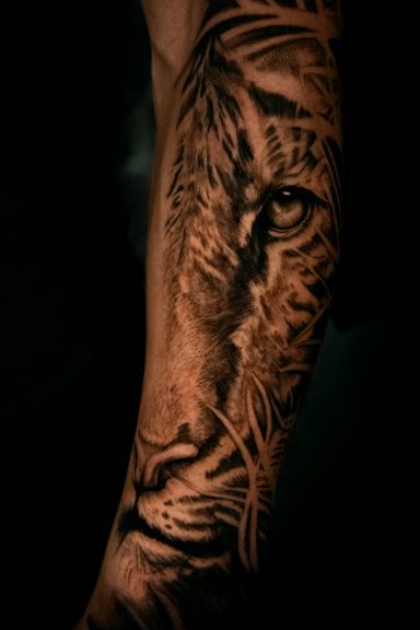Detailreiche Tätowierung eines Tigers auf dem Unterarm.